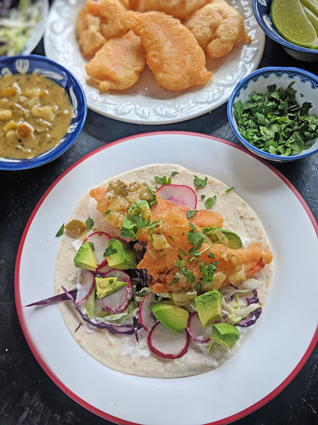 Beer-battered shrimp are stuffed into a flour tortilla with shredded cabbage, lime crema, avocado, and salsa verde for a Lenten taco.